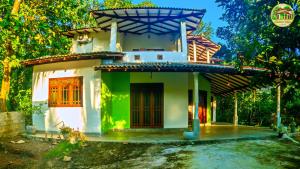 a small house with a green and white at Natura Villa in Hiriketiya