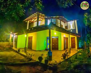 a small green and white house at night at Natura Villa in Hiriketiya +7 photos