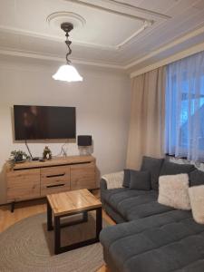 a living room with a couch and a flat screen tv at Bieszczadzka Chata Stańkowa in Ropienka