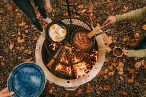 a group of people cooking food over a fire at Postcard Cabins Brown County Indiana, Outdoor Collection by Marriott Bonvoy in Columbus
