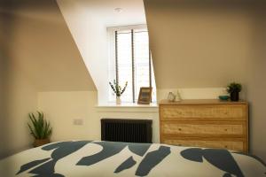 a bedroom with a bed and a window and a dresser at Coorie-In Cottage in Whitehills