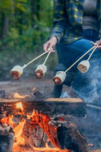 a person is cooking food on a fire at Postcard Cabins Brown County Indiana, Outdoor Collection by Marriott Bonvoy in Columbus +31 photos