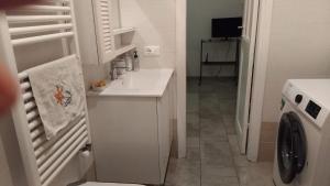 a white bathroom with a sink and a washing machine at Le 3 Sirene in Bordighera