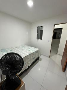 a room with a bed and a fan in it at Flat JK em Dona Inês-pb in Dona Inês