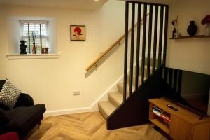 a staircase in a living room with a stair case at Coorie-In Cottage in Whitehills