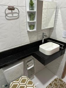 a bathroom with a sink and a toilet and a mirror at Flat JK em Dona Inês-pb in Dona Inês +6 photos