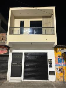a building with two garage doors and a balcony at Flat JK em Dona Inês-pb in Dona Inês