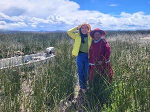 two people standing in a field of tall grass at Casa de Yolanda en Uros in Puno