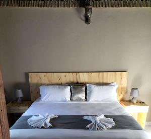 a bedroom with a bed with white sheets and pillows at Sofitel Inn in Maun