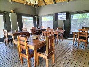 a dining room with wooden tables and chairs at Sofitel Inn in Maun