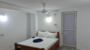 a bedroom with a bed and a ceiling fan at MH Zanzibar in Jambiani