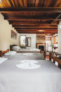 a bedroom with three beds and a fireplace at Pousada Serras De Monte Verde in Monte Verde +217 photos