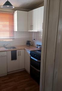 a kitchen with white cabinets and a black stove top oven at Woodhill Way Burra in Burra +20 photos