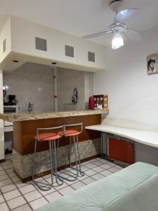 a kitchen with two stools at a counter at Pasárgada frente ao mar in Vila Velha