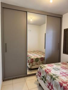a bedroom with mirrored closet doors and a bed at Casinha da Canastra in Delfinópolis