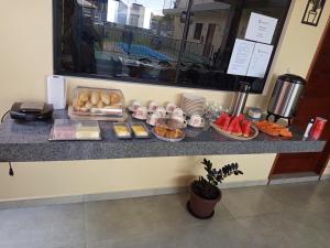a counter with pastries and other food on it at Pousada Iza in Salinópolis +13 photos