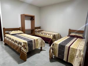 a room with three small beds in a room at Pousada Iza in Salinópolis