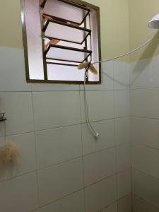 a bathroom with a shower with a window and a shower at Casinha da Canastra in Delfinópolis +10 photos