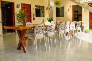 a conference room with a wooden table and white chairs at Pousada Iza in Salinópolis
