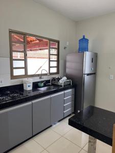 a kitchen with a stainless steel refrigerator and a window at Casinha da Canastra in Delfinópolis