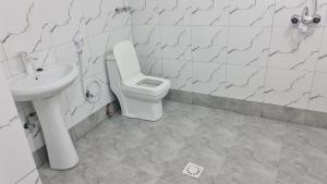 a bathroom with a toilet and a sink at MH Zanzibar in Jambiani