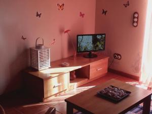 salon z telewizorem i stołem w obiekcie Adega Ramalho w mieście Canto da Areia