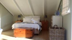 a bedroom with a bed and a trunk in it at Pondok in Paternoster