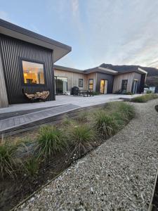 a modular home with a patio and landscaping at Pakawau Princess in Pakawau