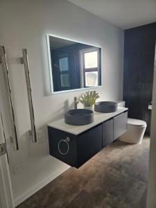 a bathroom with two sinks and a mirror at Pakawau Princess in Pakawau +18 photos