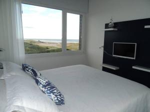 una camera da letto con un letto con un cuscino e una finestra di Linda Bay Playa a Mar de las Pampas