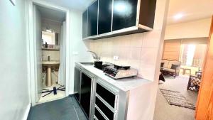 a kitchen with a sink and a stove top oven at Tabarja Chalet Studio Sea & Mountain View in An Nā‘ūrah