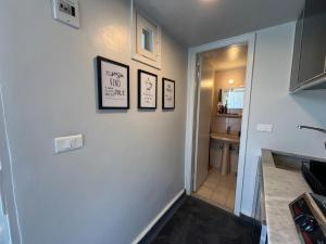 a hallway with three pictures on a wall with a bathroom at Tabarja Chalet Studio Sea & Mountain View in An Nā‘ūrah +18 photos