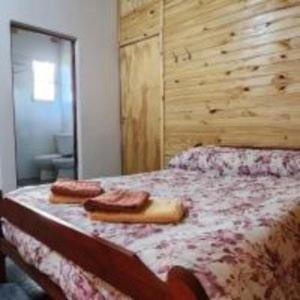 a bedroom with a bed with two towels on it at Yacaré INN in Ituzaingó