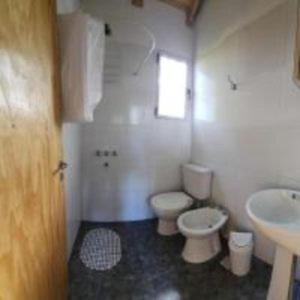a bathroom with a toilet and a sink at Yacaré INN in Ituzaingó