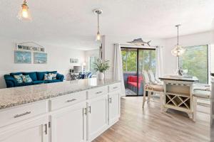 a kitchen with white cabinets and a dining room at Golf Glenn Villa A205 in Myrtle Beach