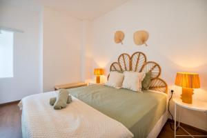a bedroom with a large bed with two lamps and two tables at Ocean View - XL Terrace - Beachfront by Tenório in Lagos +11 photos
