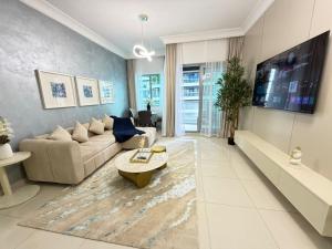 a living room with a couch and a tv at Damac mall street in Dubai
