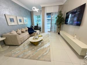 a living room with a couch and a tv at Damac mall street in Dubai