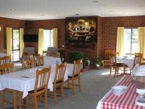 a dining room with white tables and wooden chairs at Milawa Motel in Milawa