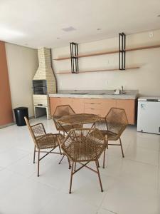 a table and chairs in a room with a kitchen at Praia dos Corais apt 79 in Santa Cruz Cabrália