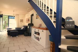 a living room with a staircase and a couch at "Leuchtturm" in Fuhlendorf