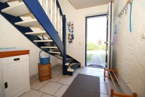 a staircase in a house with a blue stair railing at "Leuchtturm" in Fuhlendorf