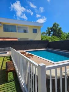 a swimming pool on a deck next to a house at Praia dos Corais apt 79 in Santa Cruz Cabrália