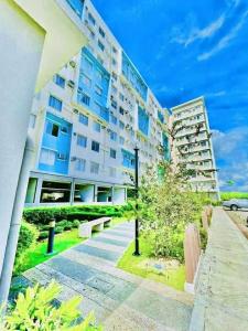a large apartment building with a park in front of it at ONE SPATIAL 2Bedrooms Apartment Flat LLD Iloilo City Philippines in Iloilo City