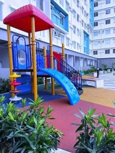 a playground with a slide in front of a building at ONE SPATIAL 2Bedrooms Apartment Flat LLD Iloilo City Philippines in Iloilo City