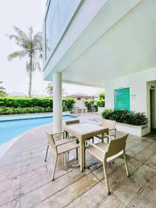 a patio with a table and chairs and a pool at ONE SPATIAL 2Bedrooms Apartment Flat LLD Iloilo City Philippines in Iloilo City