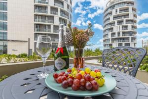 a table with a plate of fruit and a bottle of wine at Ellipse Soleya in Midrand