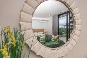 a mirror in a living room with a green couch at Ellipse Soleya in Midrand