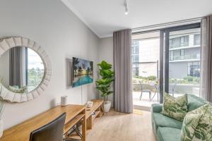 a living room with a green couch and a table at Ellipse Soleya in Midrand