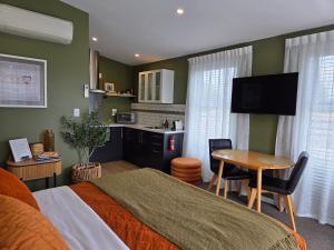 a bedroom with a bed and a table and a kitchen at “No.25”Stand alone guest studio unit in Twizel +4 photos